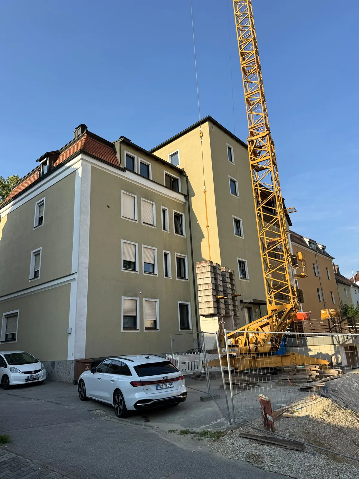 Mehrfamilienhaus in Straubing während der Sanierung, daneben ein Baukran, Referenzobjekt 03
