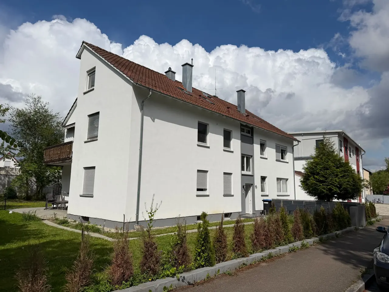 Weißes Mehrfamilienhaus mit rotem Satteldach und Garten in Ulm, Referenzobjekt 05